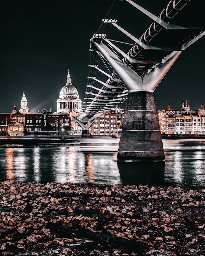 Dramatic night view of Londons Millennium Bridge with St. Pauls Cathedral in the backdrop.